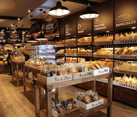 Interior de sucursal con estanterías de panadería